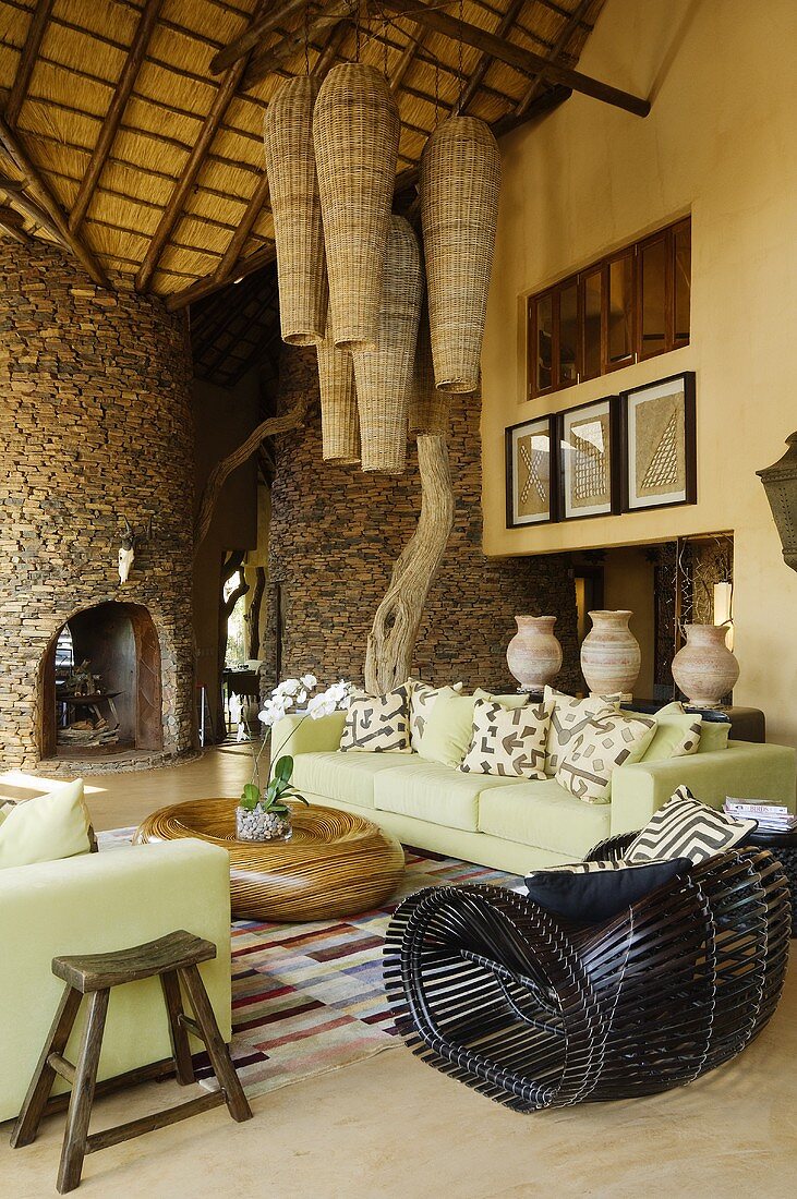 Wohnraum im südafrikanischen Haus - Deckenlampe mit Korbschirmen über hellgrüner Sofagarnitur