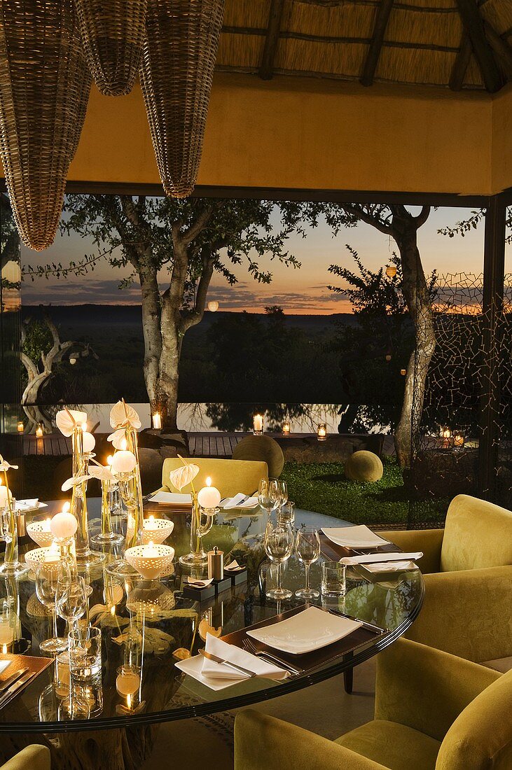 Gedeckter Tisch mit Kerzenlicht auf Terrasse eines südafrikanischen Hauses