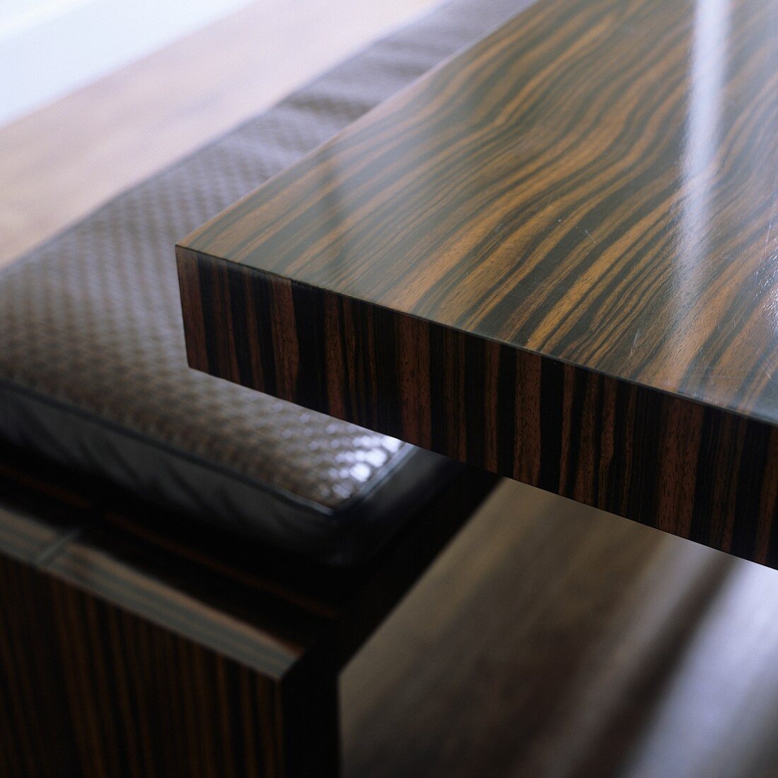 A veneered table made of tropical wood and a bench upholstered in leather