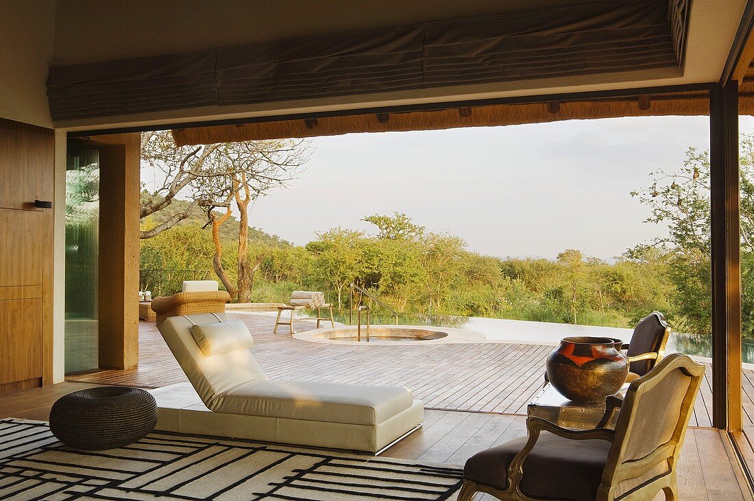 Terrasse eines südafrikanischen Hauses mit Bodenliege und antiken Stühlen