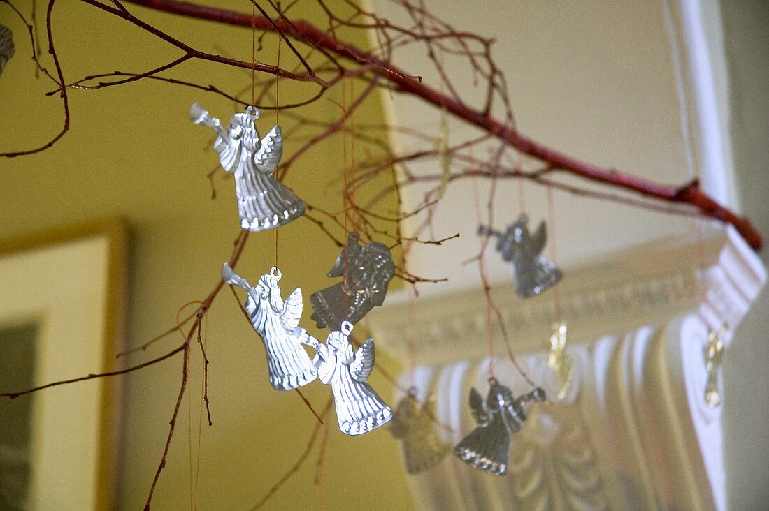 Silver Christmas angels hanging from a tree branch