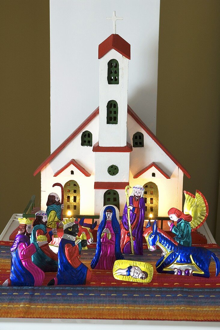 Colourful nativity figures in front of a model church