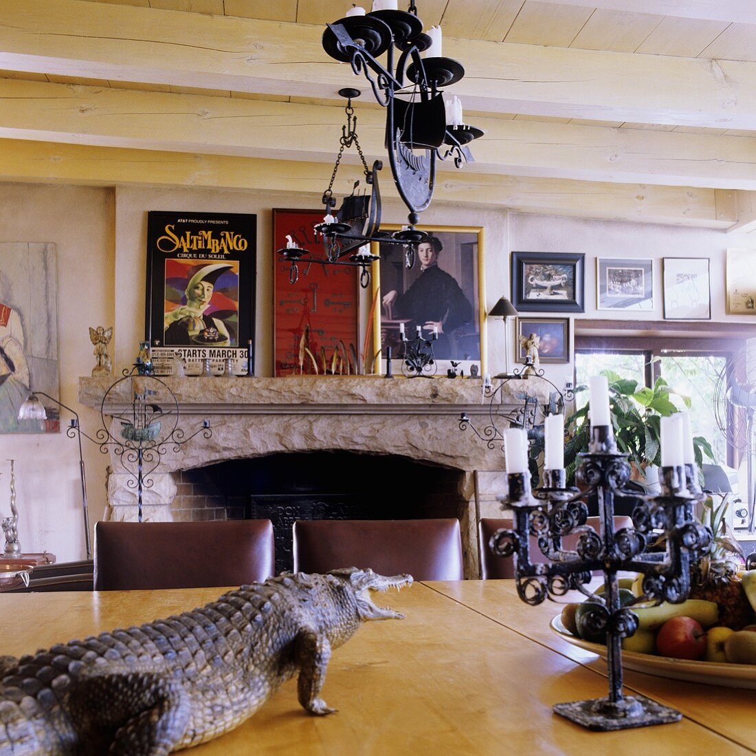 Esszimmer mit Holzbalkendecke im südafrikanischen Landhaus - ausgestopftes Krokodil und Kerzenleuchter auf Tisch