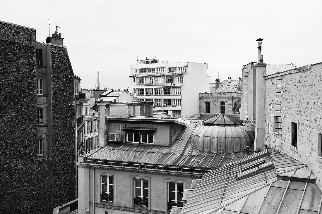 A black and white photo of a roofscape in Paris