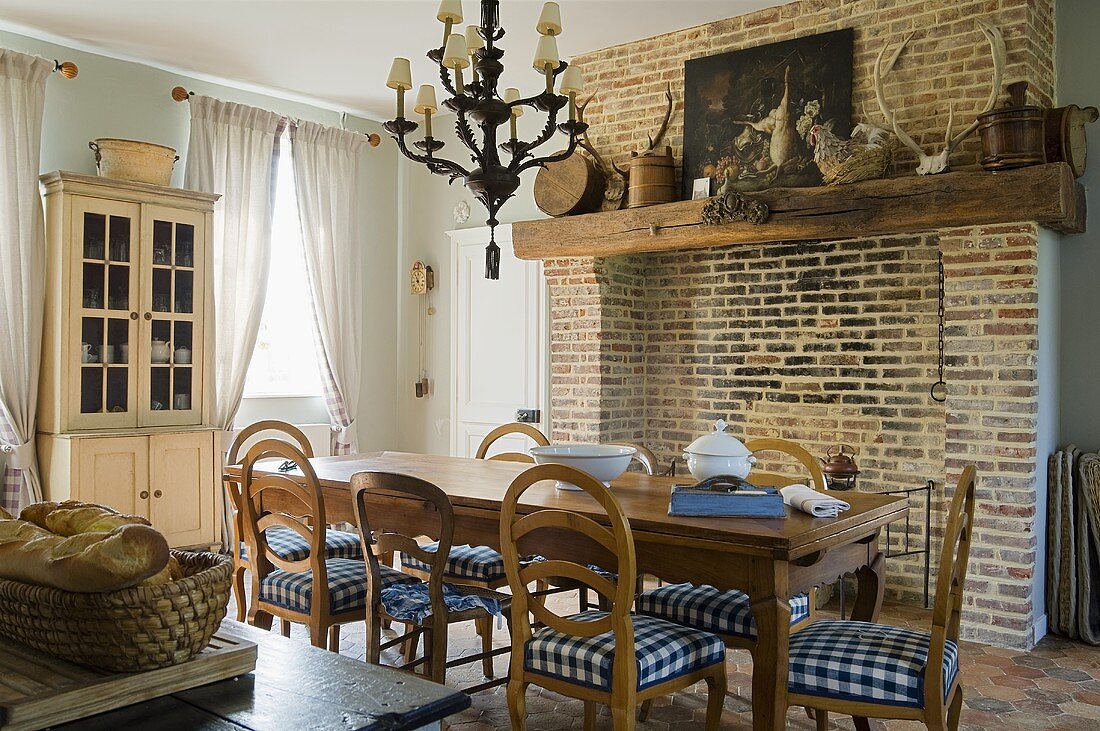 A dining room in a country house and a brick wall with a fireplace