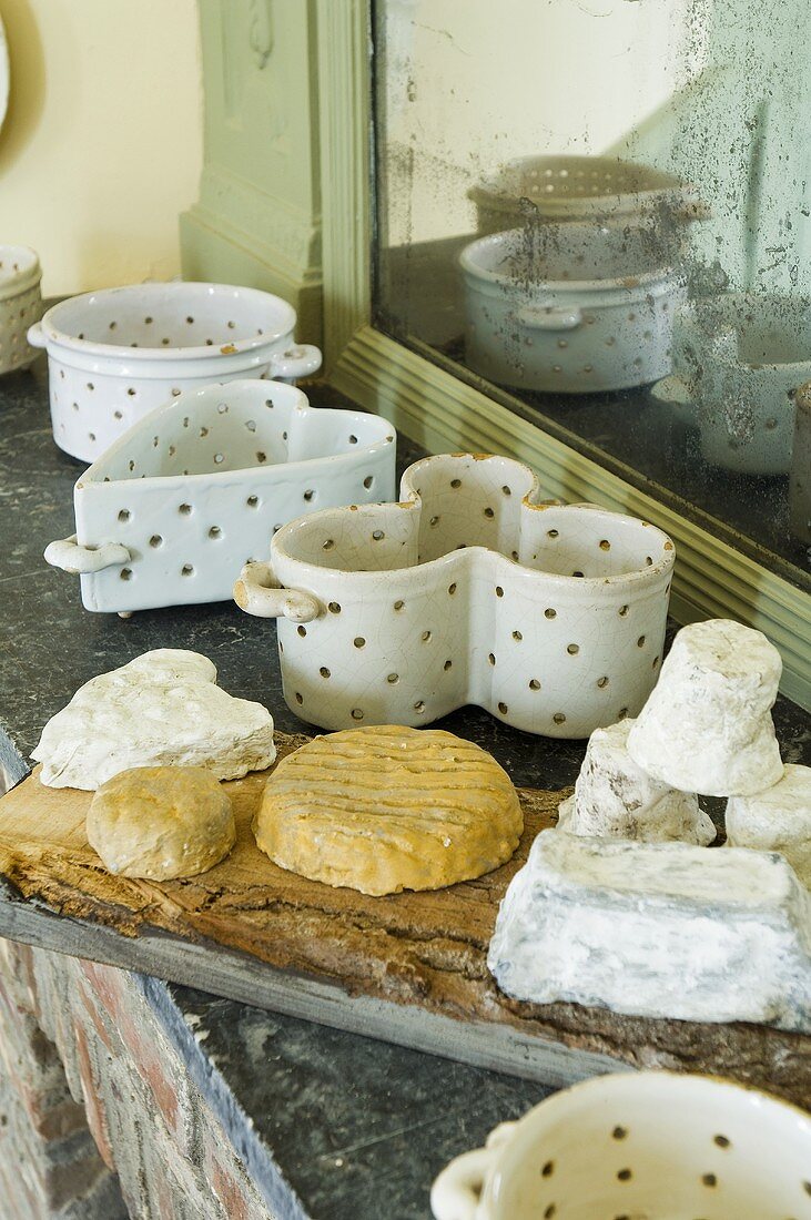 French cheese on a stone shelf with antique cheese dishes