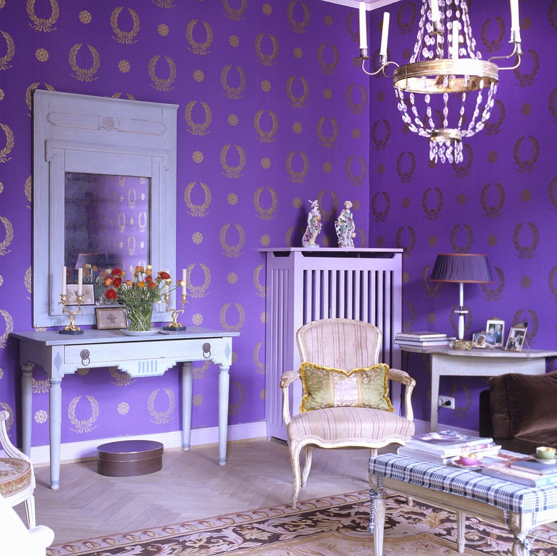 A living room with a Rococo chair and a country house-style wall table against a wall hung with purple and gold wallpaper