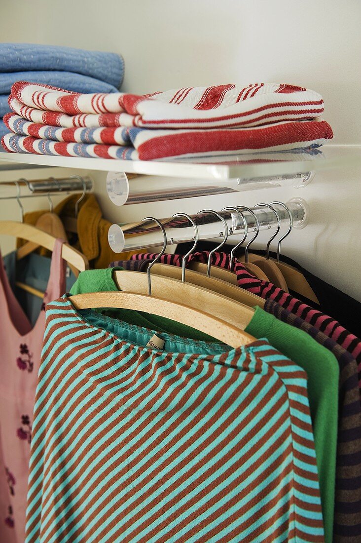 Kleidung auf Kleiderständer und Ablage