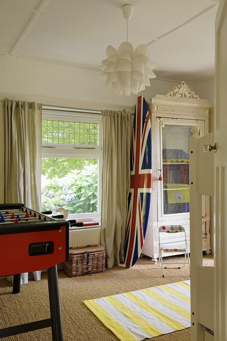 A boy's bedroom - a Union flag on a surf board next to a window with a view