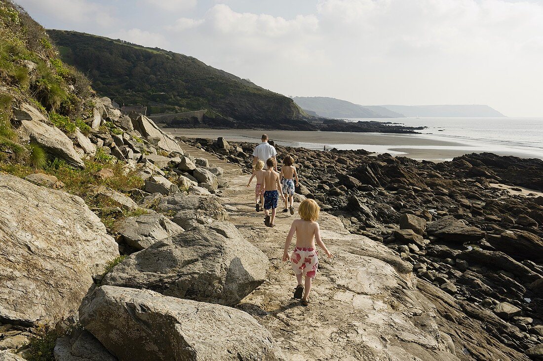 Walking with children on a rocky path by the seashore