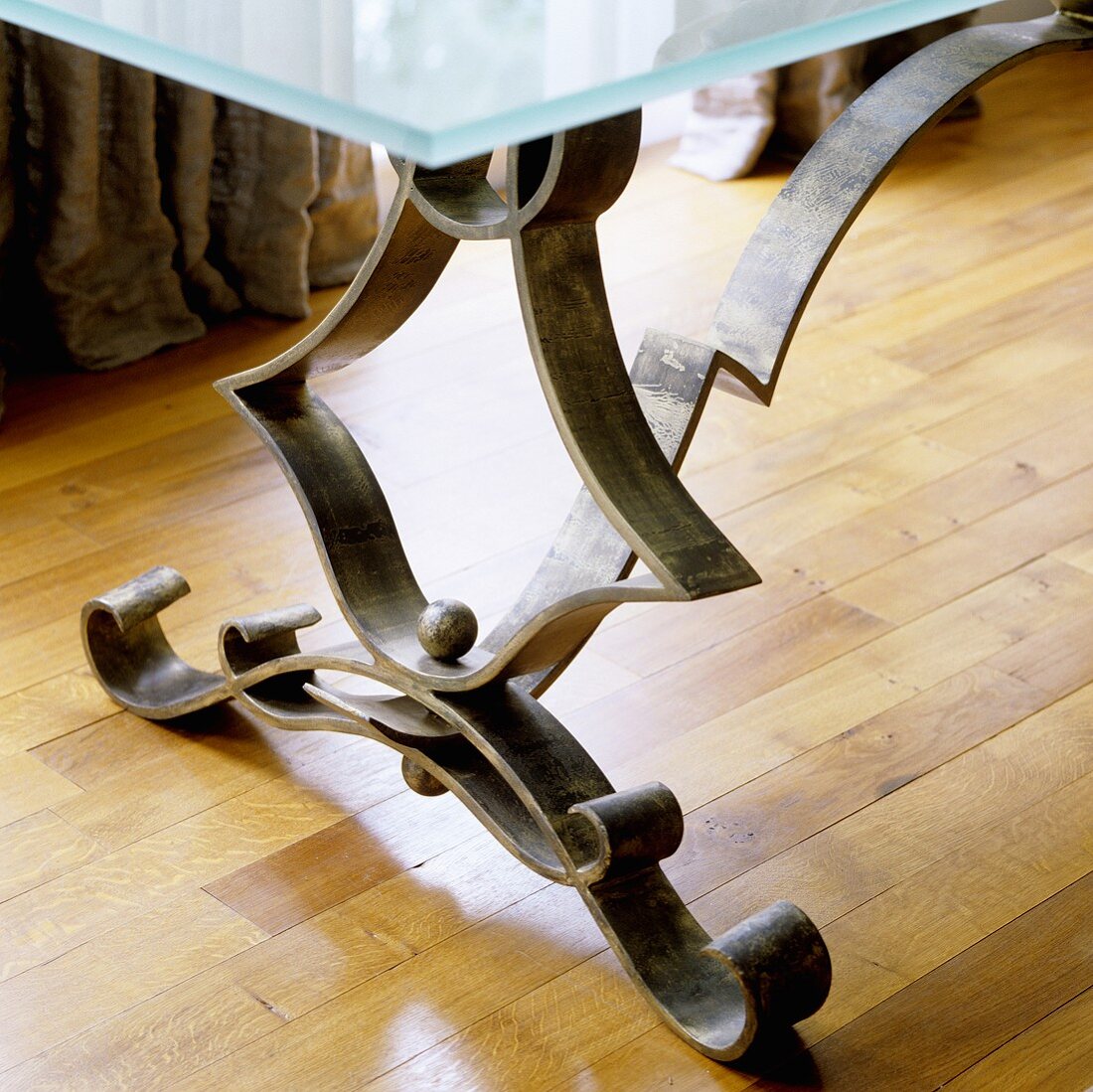 A metal table leg on parquet
