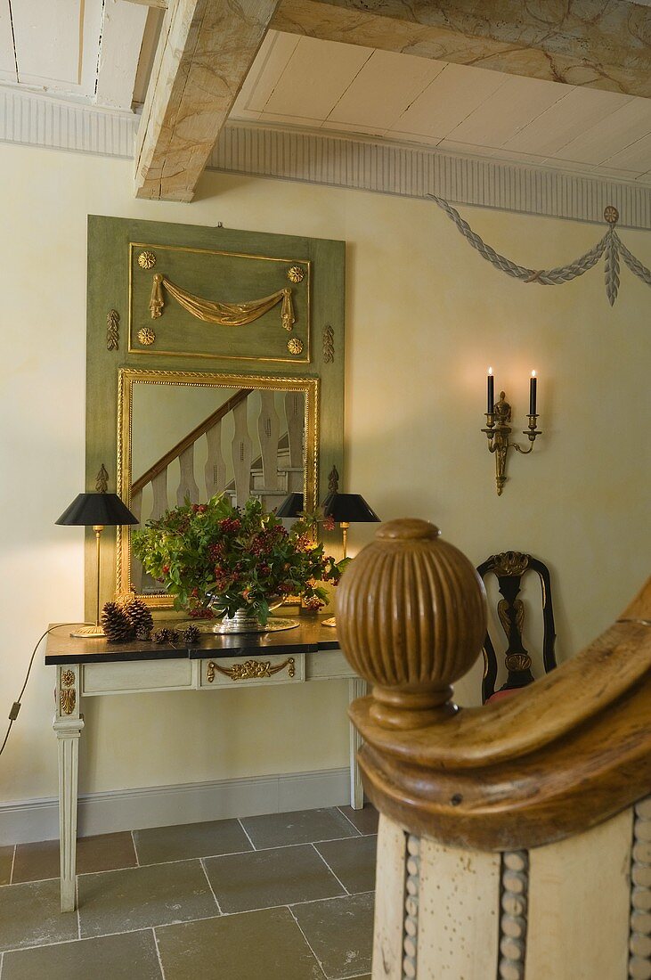 A hallway in a country house with a classical wall table and and mirror