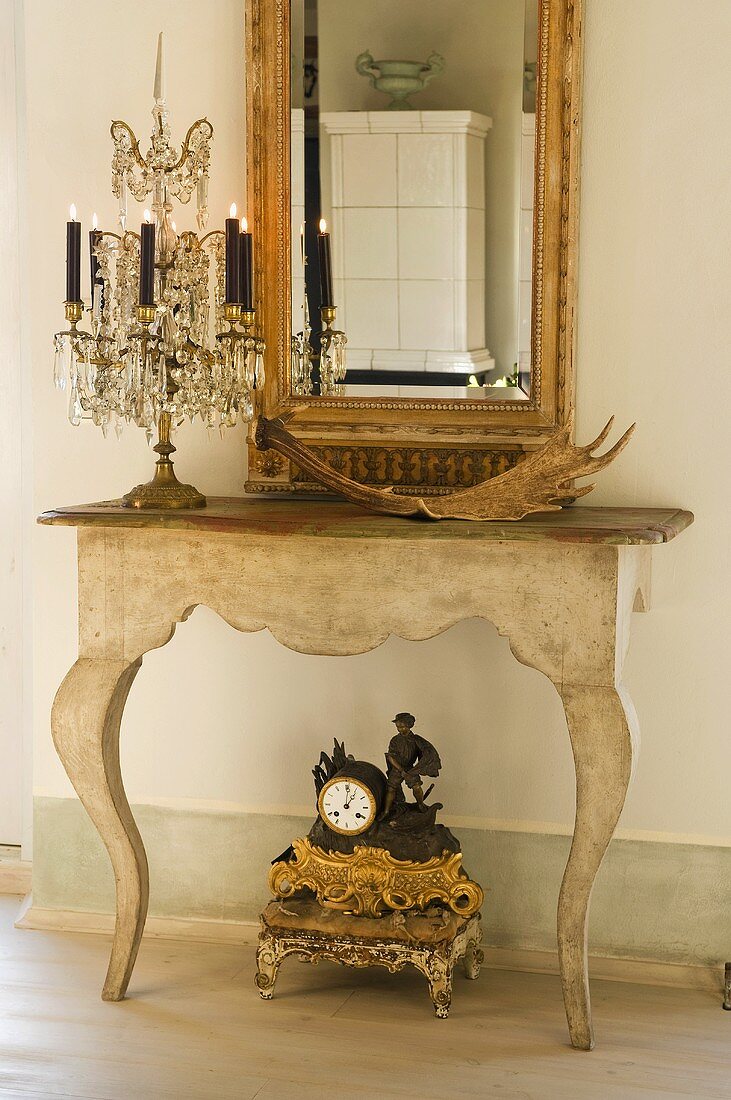 Crystal candelabra an a stripped baroque console table with mirror