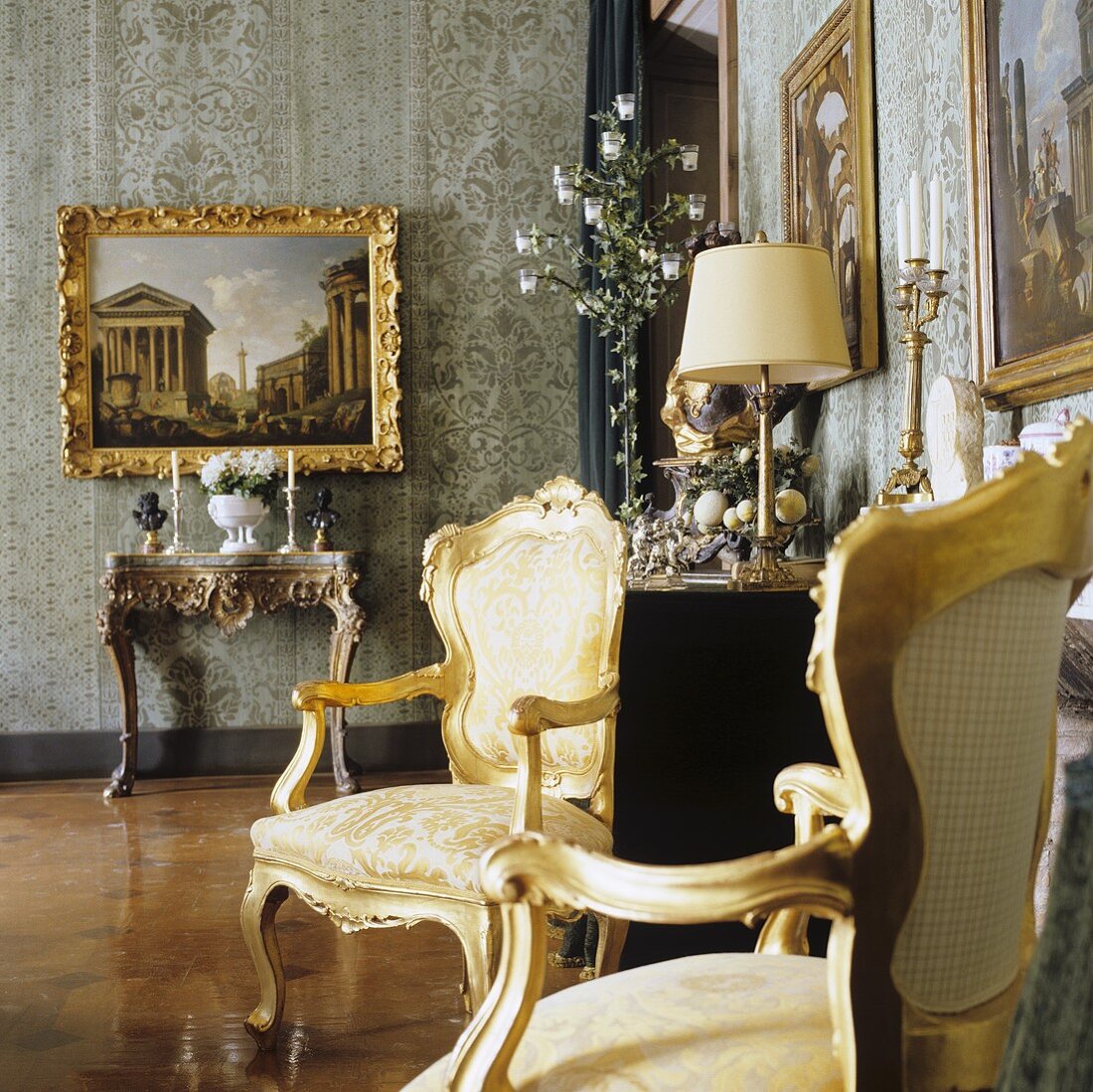 Rokokostühle mit Goldrahmen und Bild über Konsolentisch in einem Palazzo
