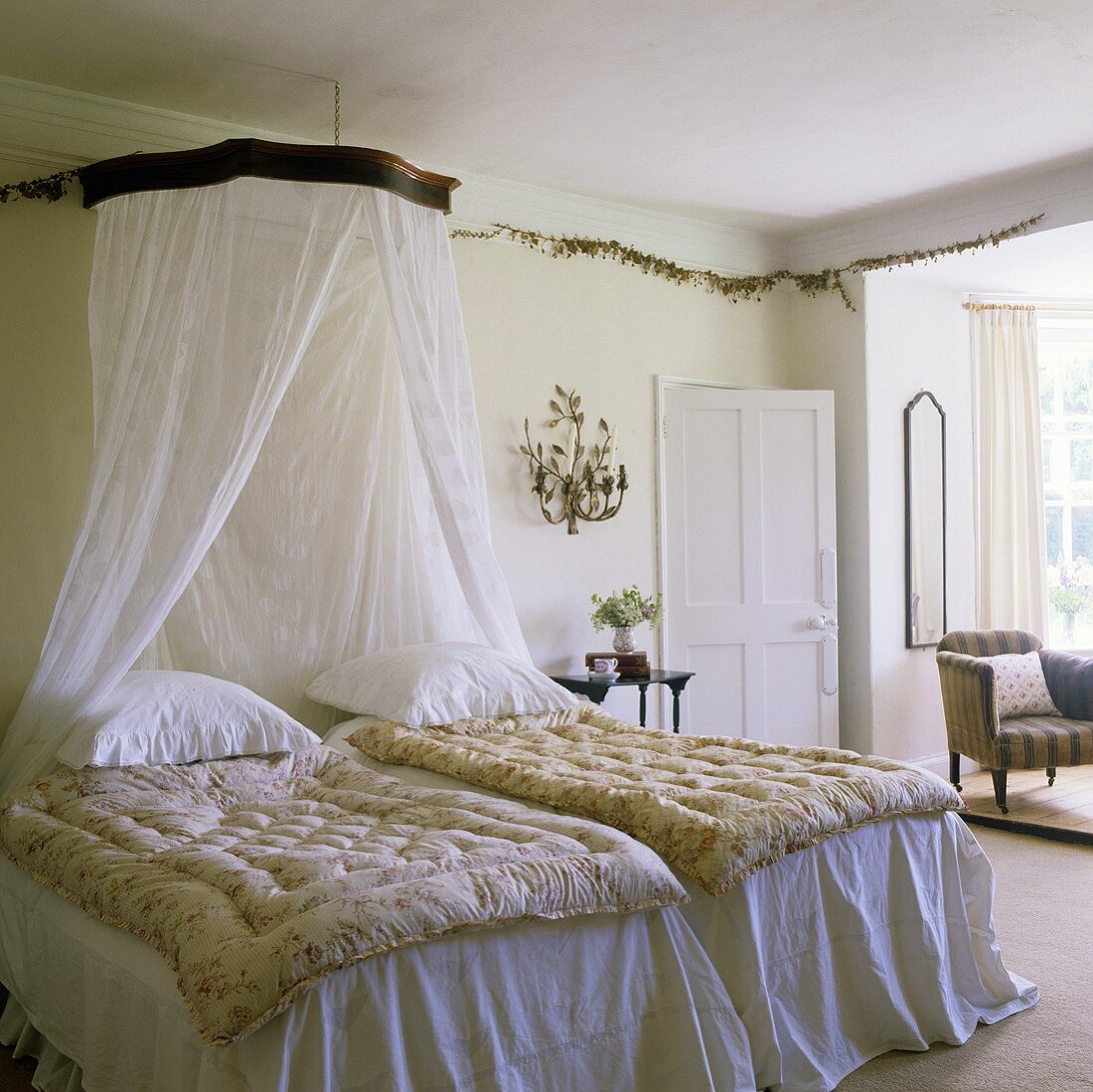 A bedroom in an English country house with a canopy and white bedclothes