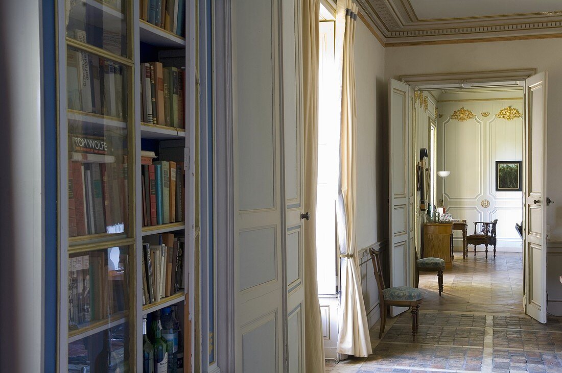 An anteroom with a library cupboard and view into a neighbouring living room