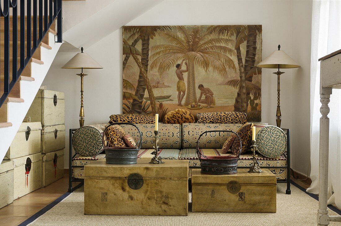 Antique wooden trunks in front of an upholstered loungers in a Mediterranean stairwell