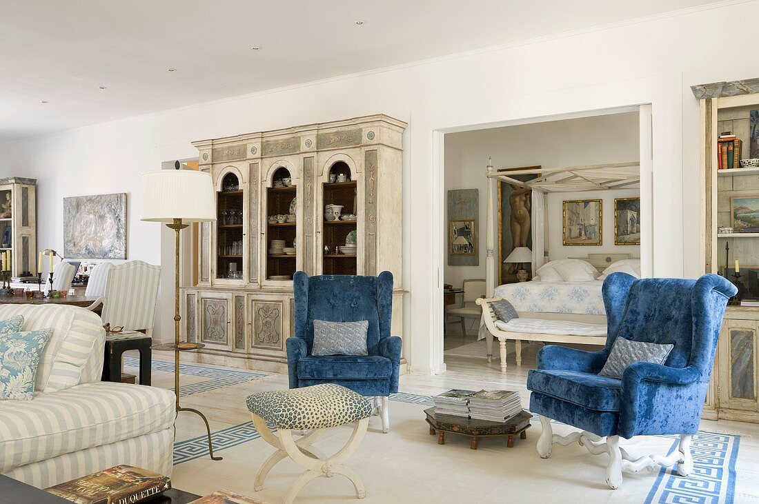 Mediterraner Wohnraum mit blauen Ohrensesseln und Möbeln im Landhausstil