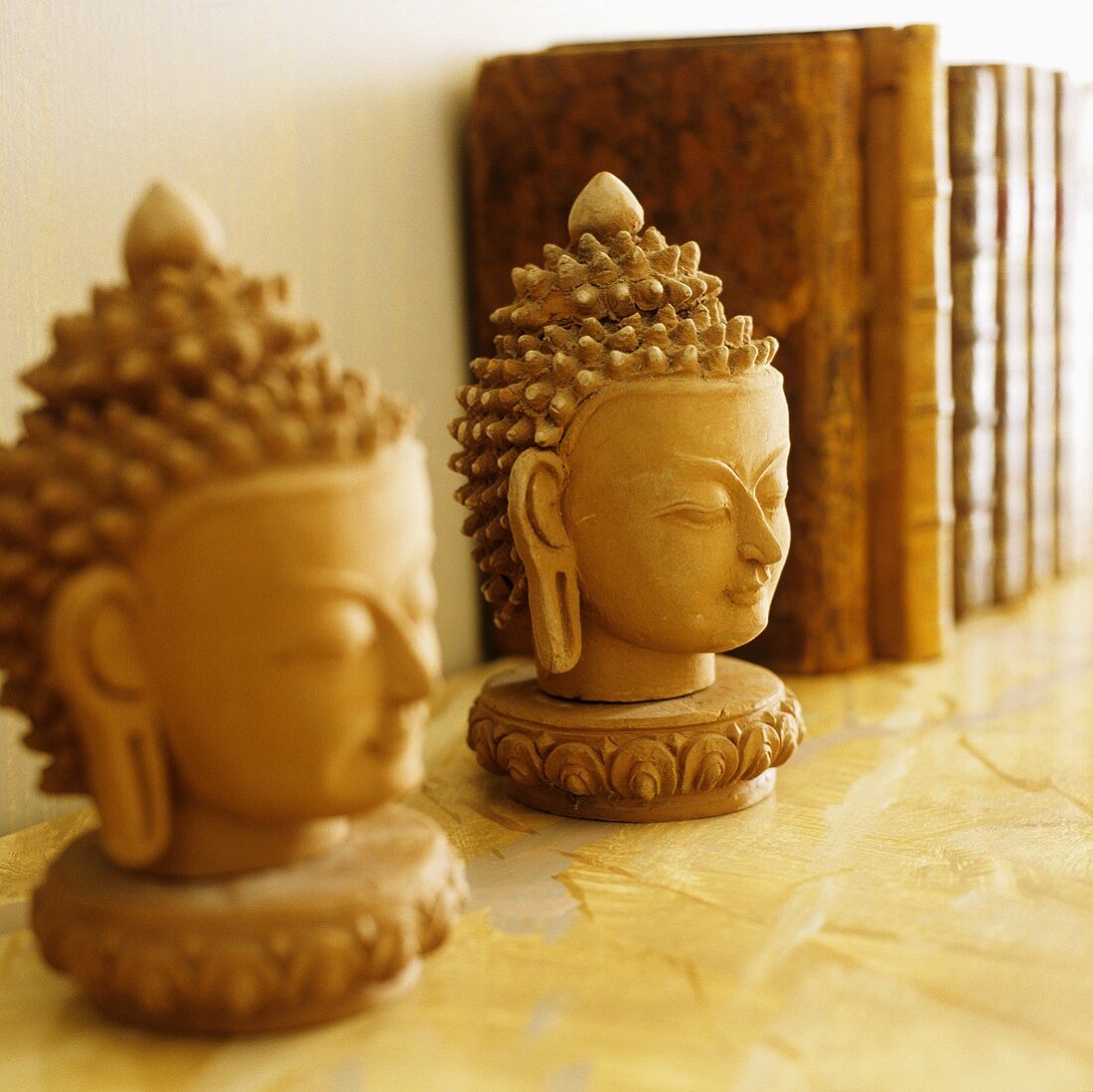 Oriental Buddha heads on a book shelf