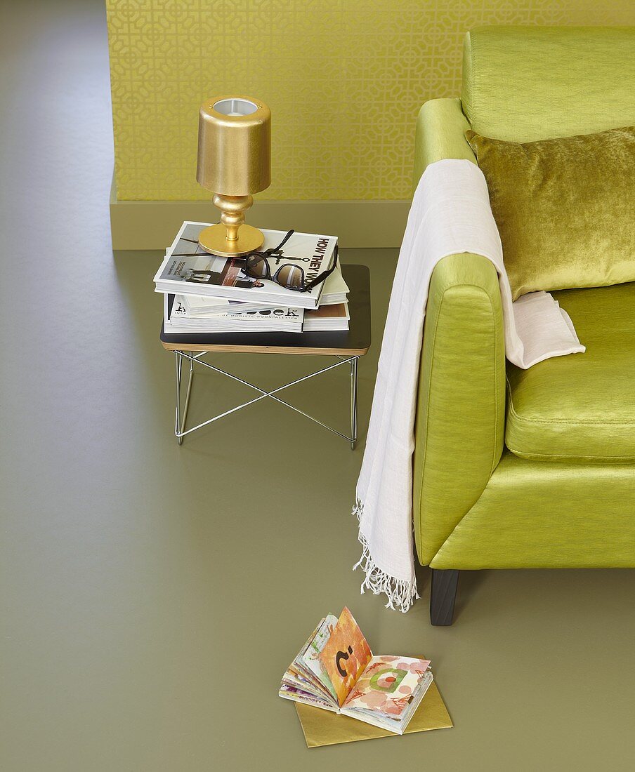 Shades of green - a sofa and a mini side table against a wall