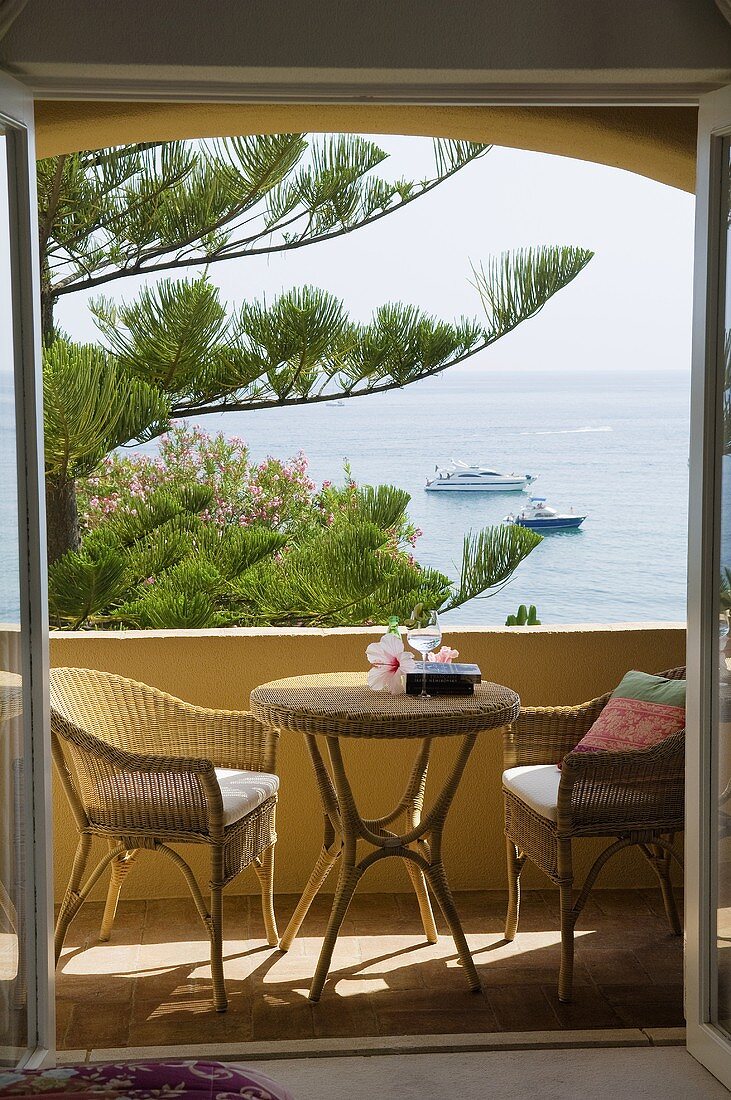 Blick auf Balkon mit Korbmöbeln und Meeresblick