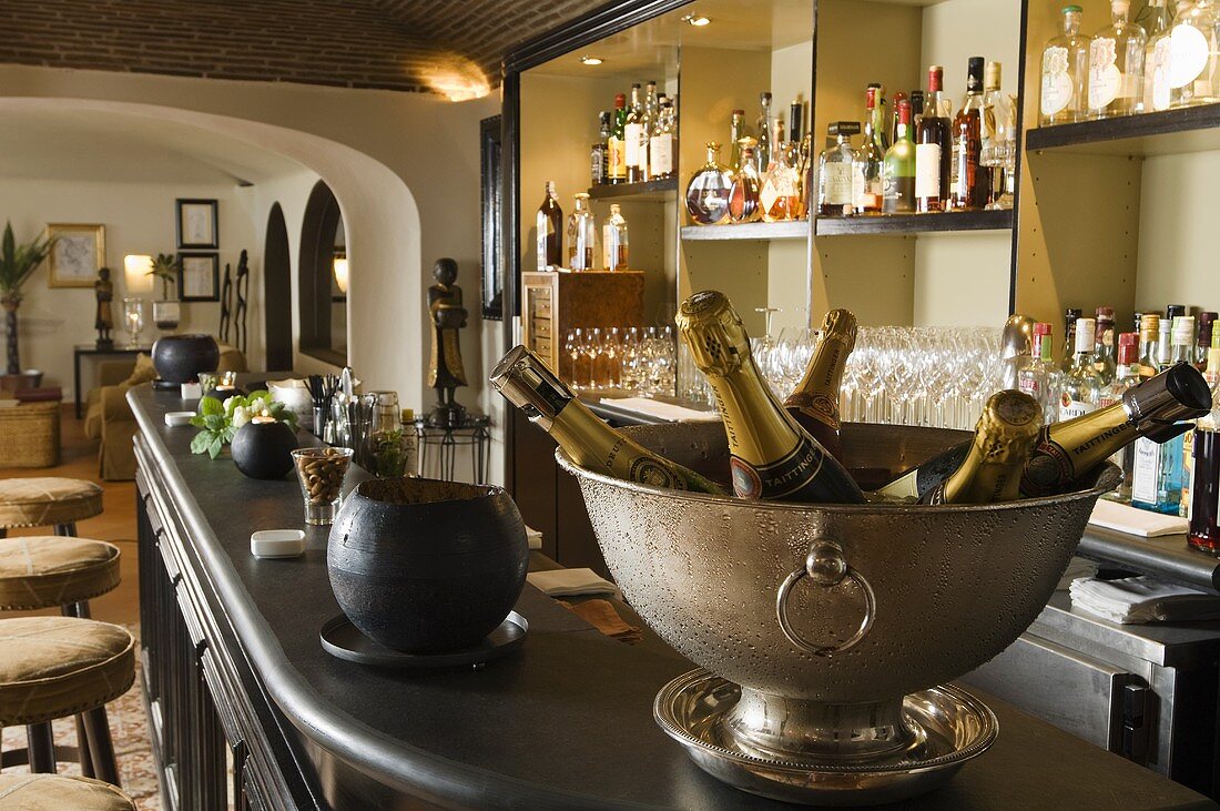A bar - champagne bottle in a chiller on the bar with a view into a lounge