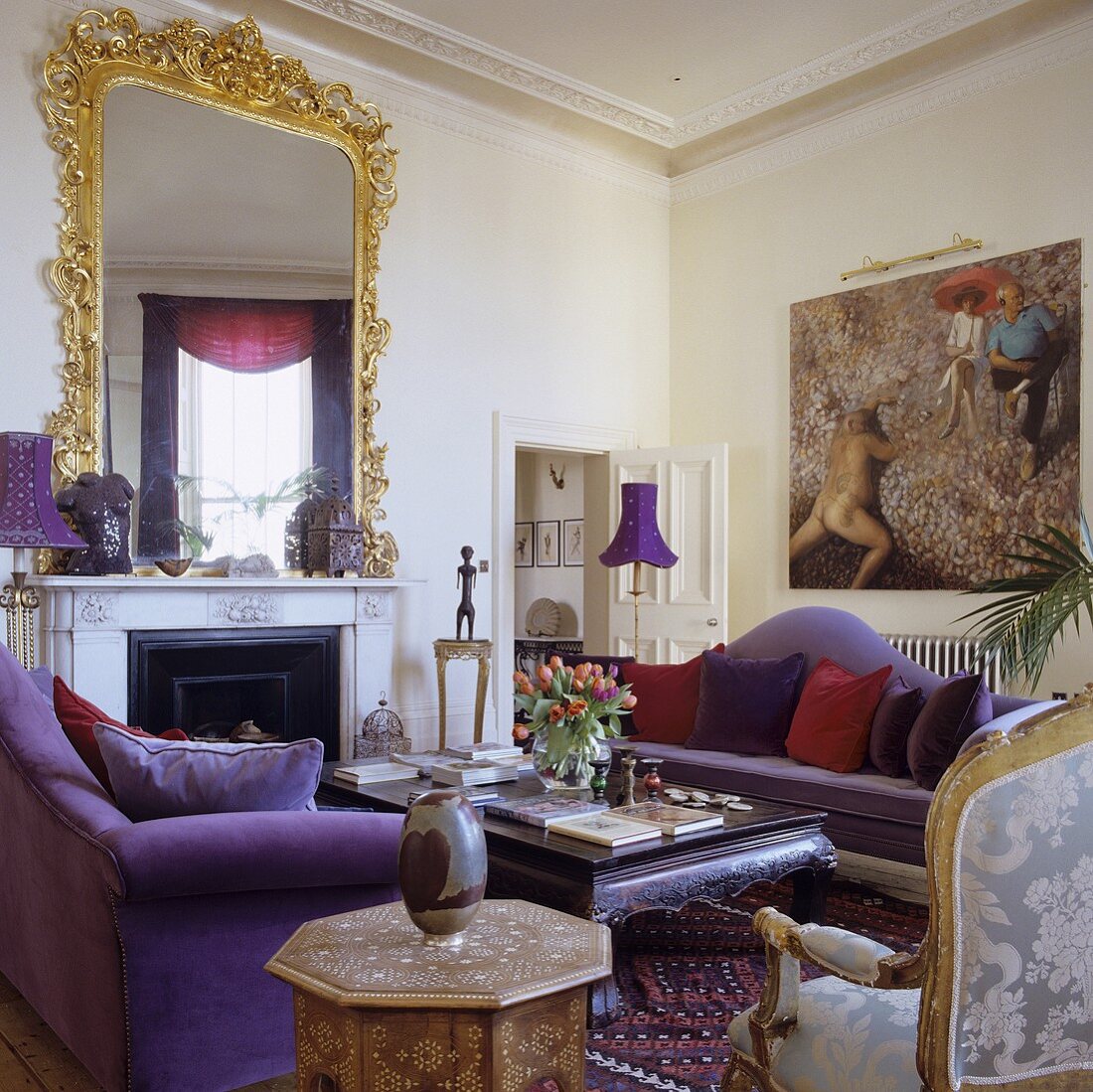 A luxury apartment with purple sofas in front of a fireplace with a Rococo mirror