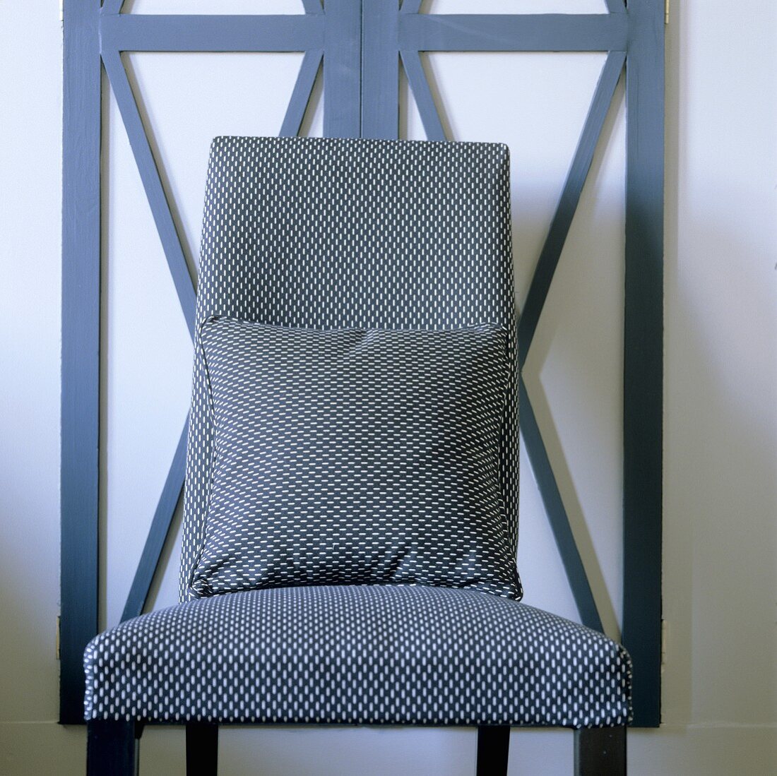 An upholstered chair with a matching cushion