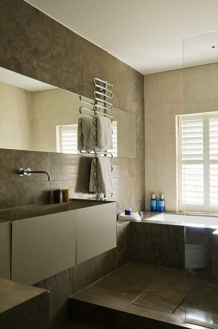 A multi-functional designer bathroom with brown wall and floor tiles