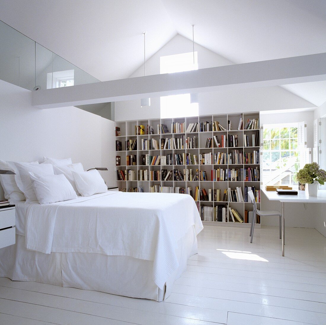 Schlafen im ausgebauten Dach mit Bücherregal und Arbeitsecke vor Giebelwand