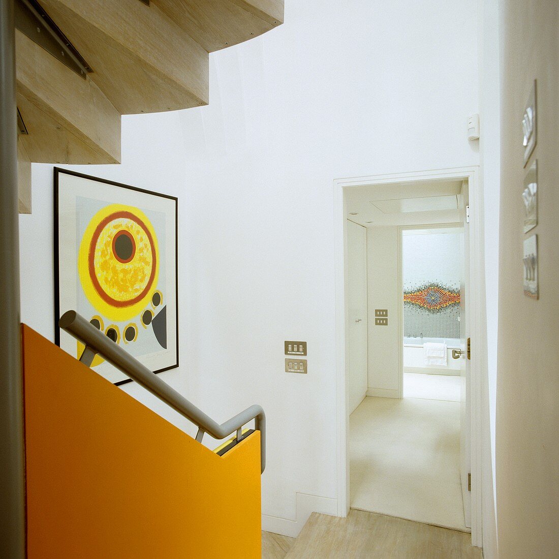 Treppe mit orangefarbenem Paneel und Handlauf mit Blick durch offene Zimmertür in Flur