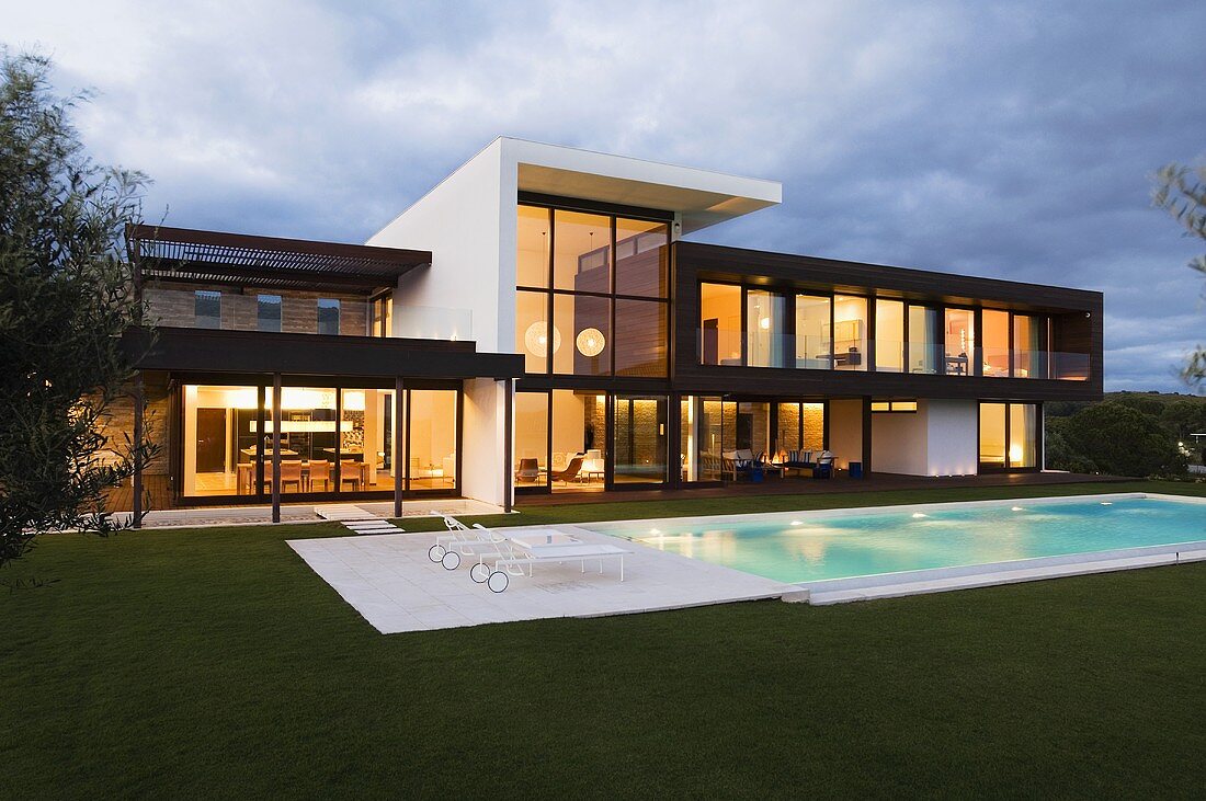 Abendstimmung - beleuchtete Villa mit Glasfassade und Pool