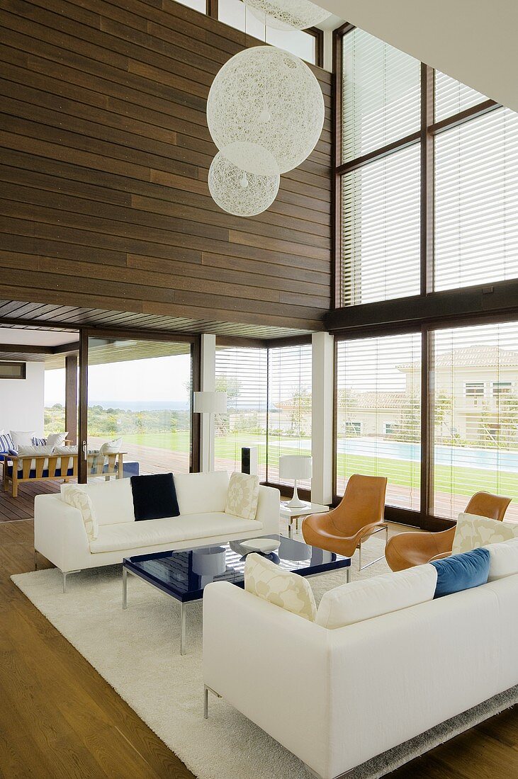 weiße Sitzgruppe mit Designerlampe in Neubau Villa mit Glasfront
