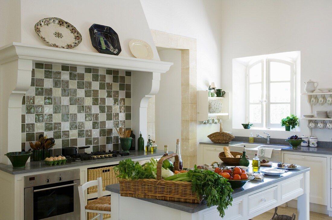 Vegetables on a kitchen table in front of a country house-style oven with an extractor fan