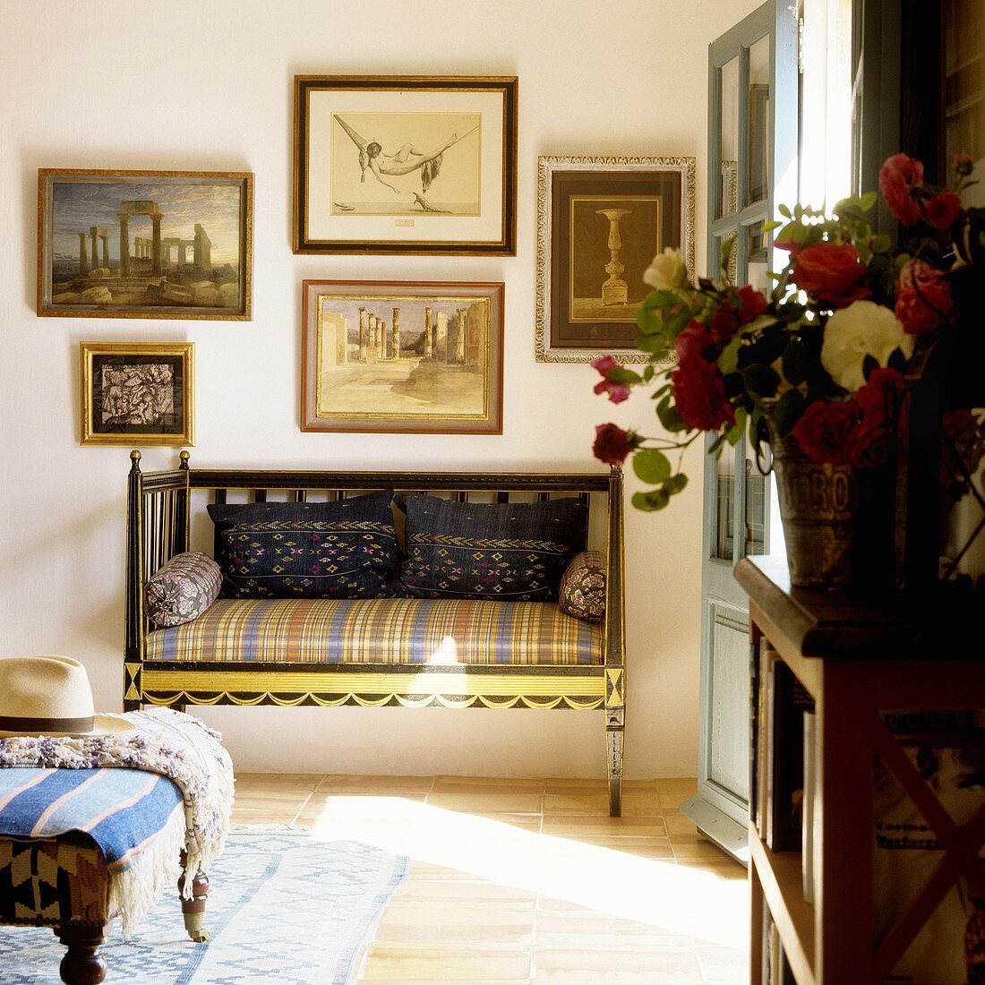 An antique bench and a collection of pictures on the wall