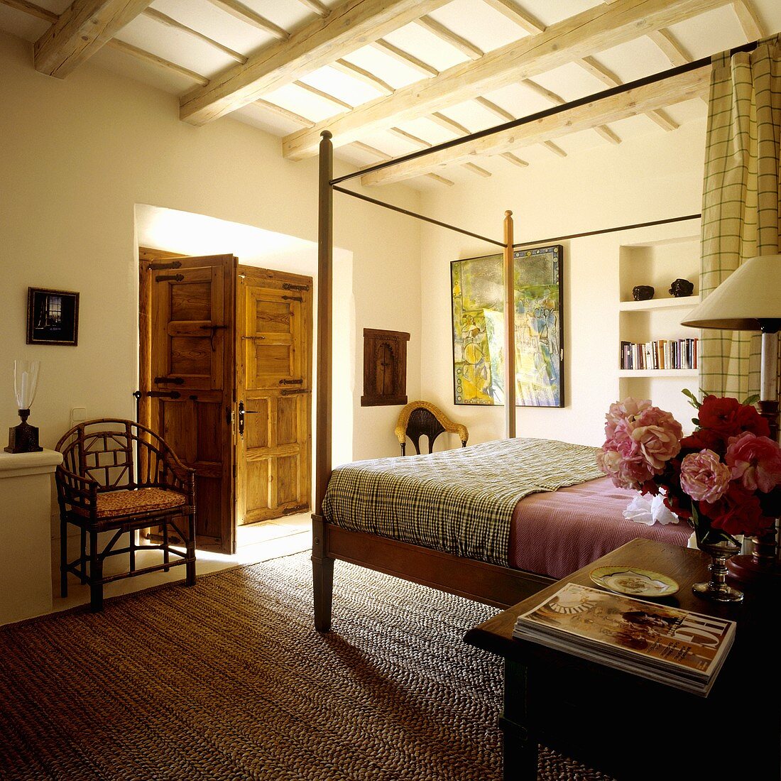 Mediterraner Schlafzimmer im Landhaus - Himmelbett auf Sisalteppich und offenstehende Holzflügeltür