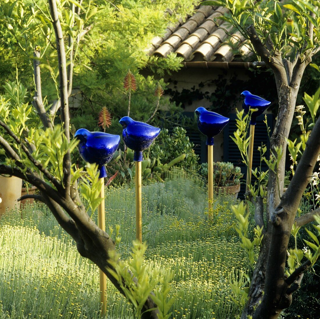 Blaue Gartendekofiguren in der Wiese