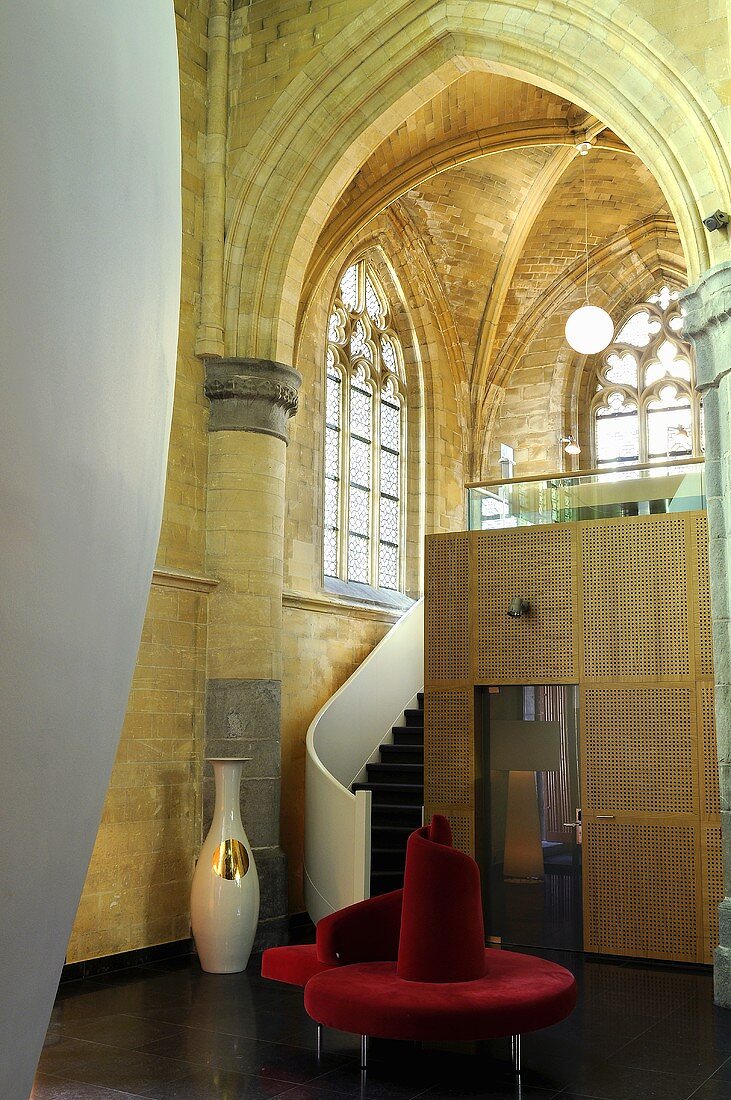 Gotischer Kirchenraum mit Einbauten - Treppe und kubischer Raumeinbau mit roter kreisförmiger Sitzbank
