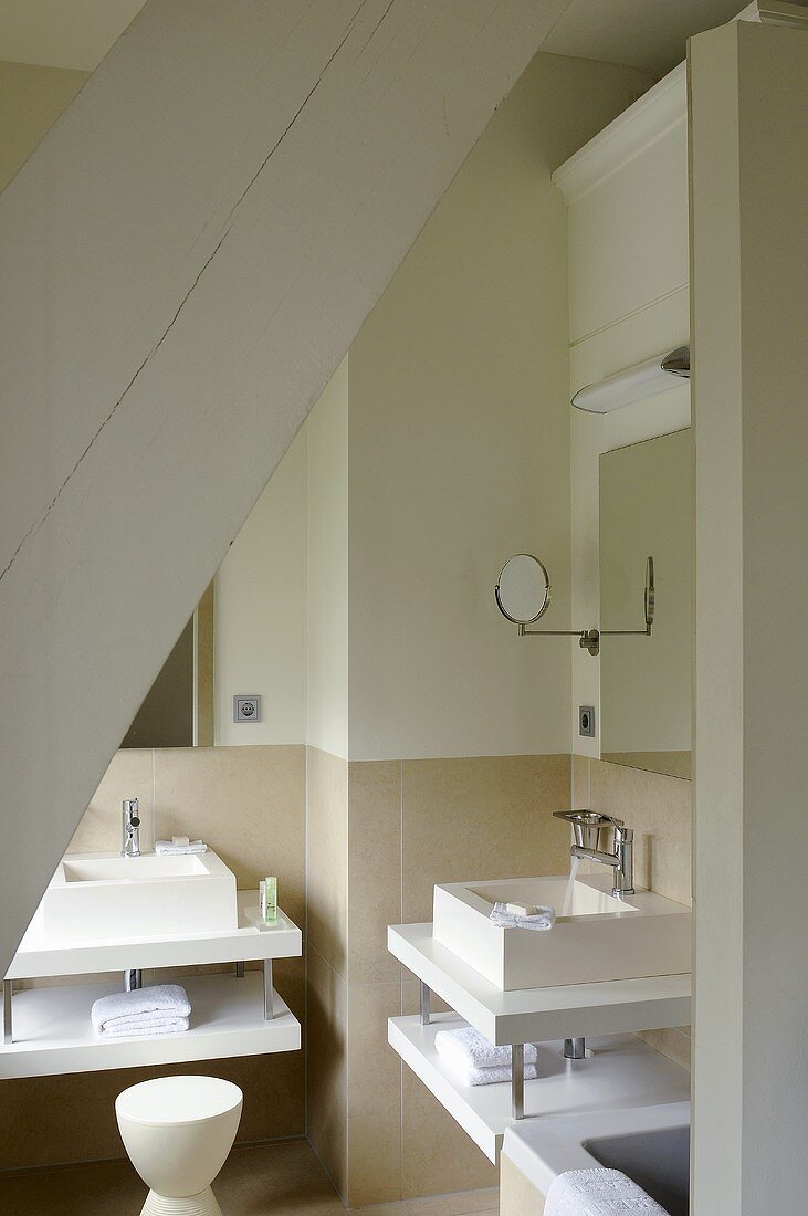A designer washstand in a minimalistic attic bathroom