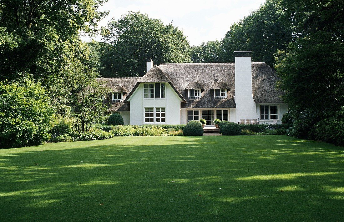 Villa mit grossen Dachflächen und Sprossenfenstern im flämischen Stil mit Garten