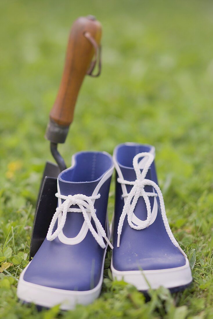 Blue galoshes and garden trowel