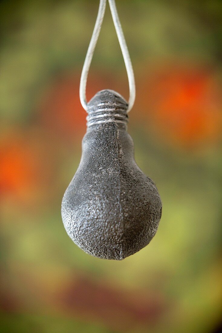 Pendant made of metal on a white cord