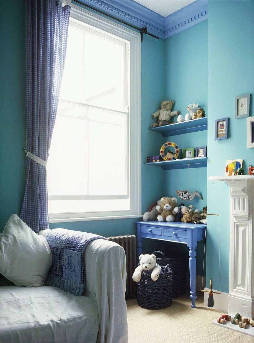 Blaue Kinderzimmerecke mit Tisch und Regalböden neben Fenster