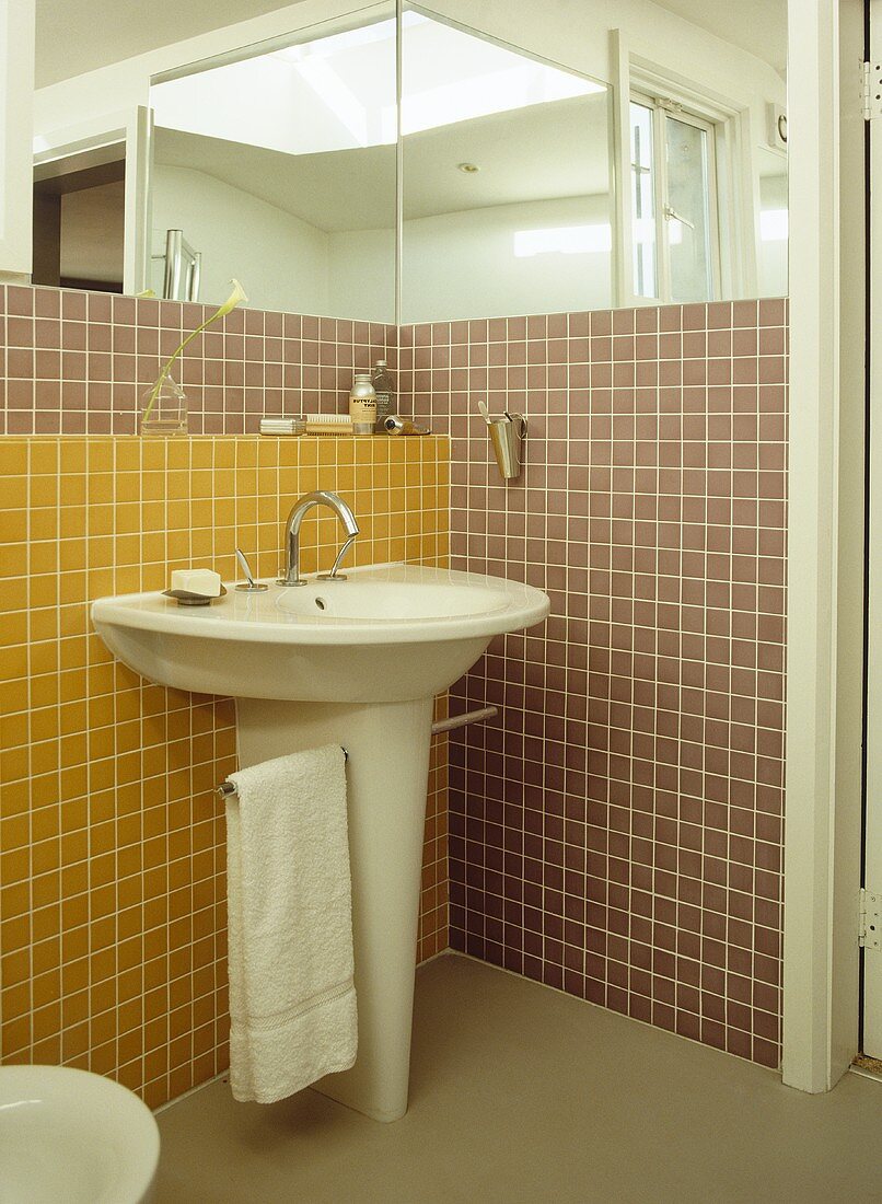 Badezimmerecke mit freistehendem Waschbecken vor gelben und braunen Mosaikfliesen