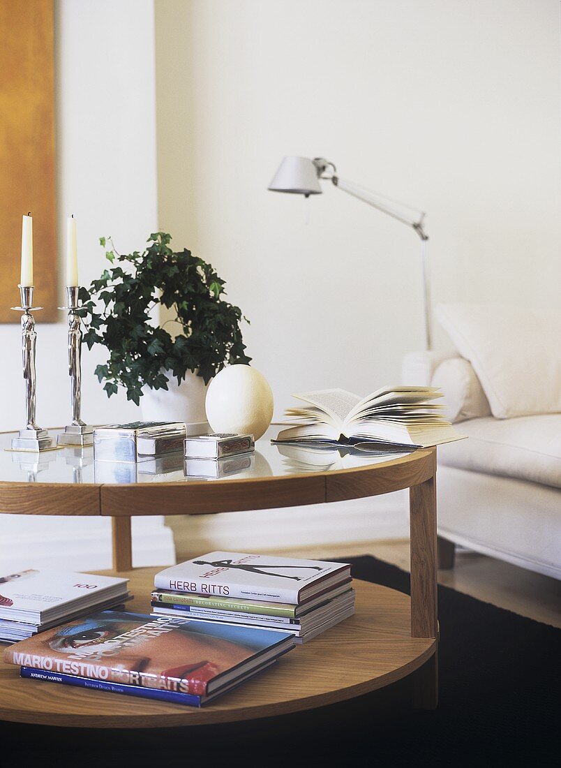 A modern, sitting room, books, glass coffee table, candles, candlesticks, house plant, lamp,