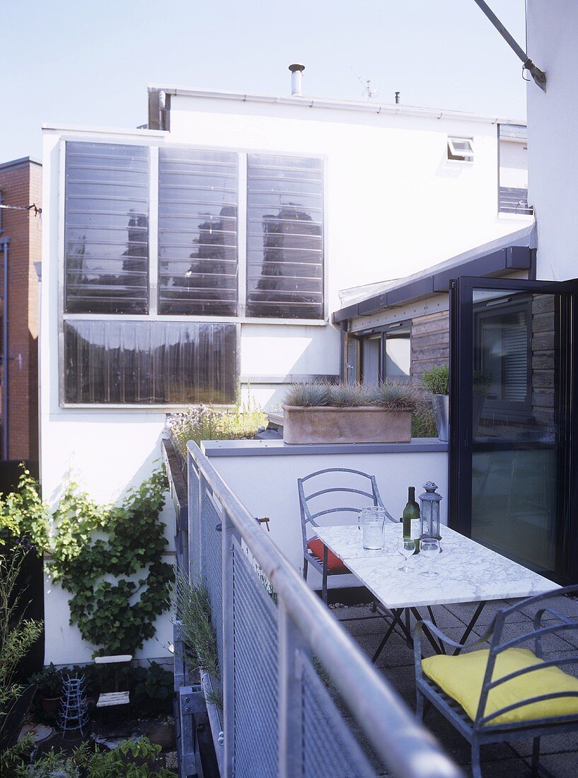Tisch und Stühle auf Balkon mit Blick auf Wohnhaus