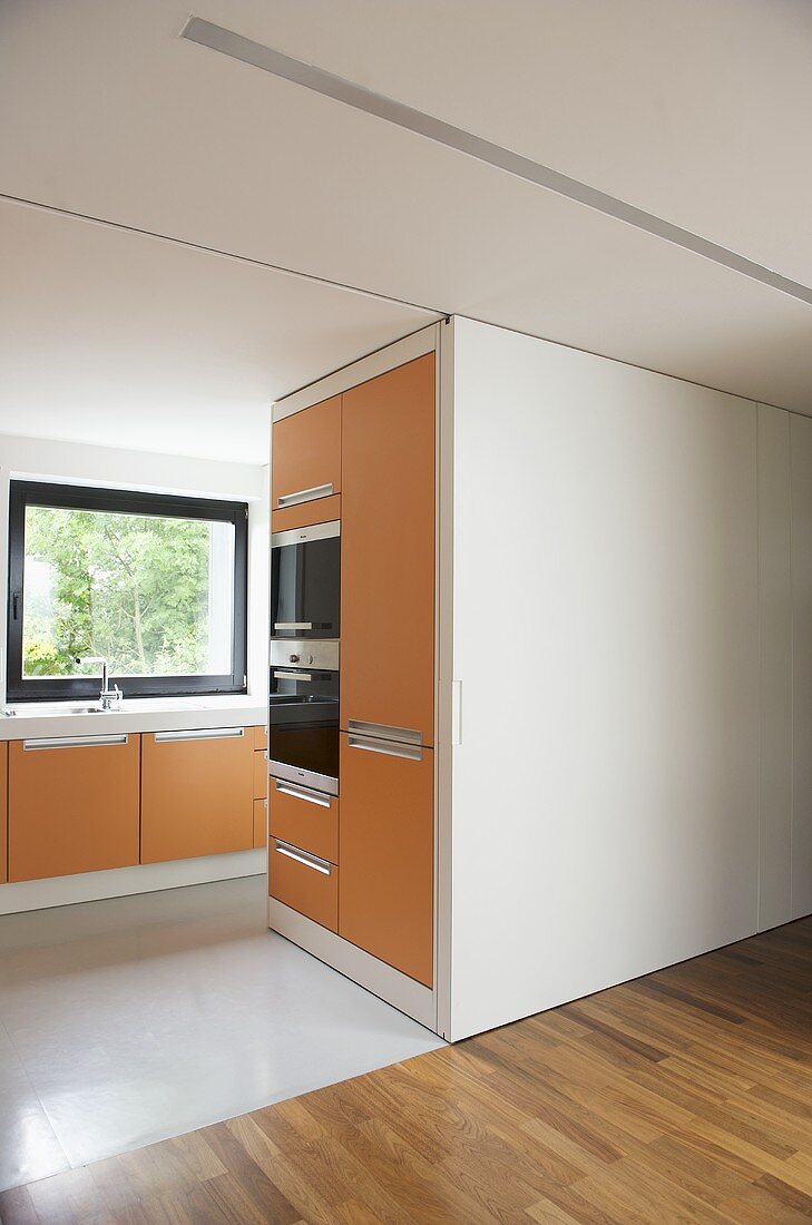 Moderne offene Küche mit orangefarbenen Fronten