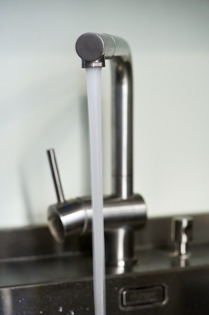 Water running from stainless steel kitchen tap fitting