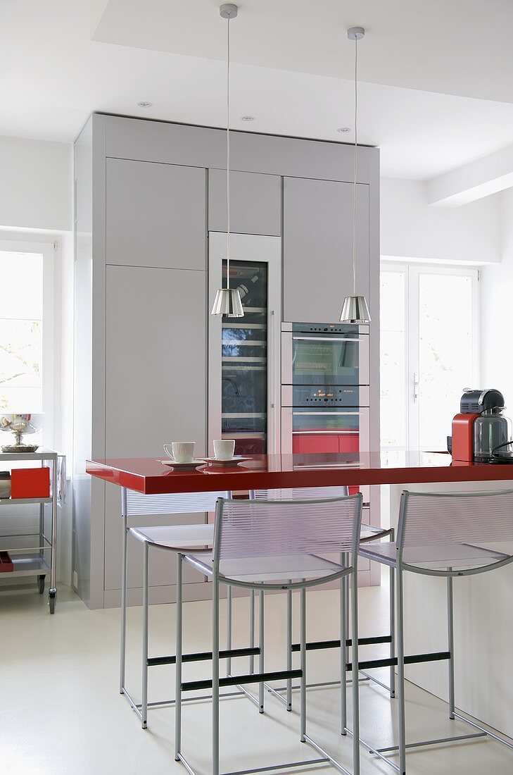 Barhocker und Theke mit roter Platte in moderner Küche