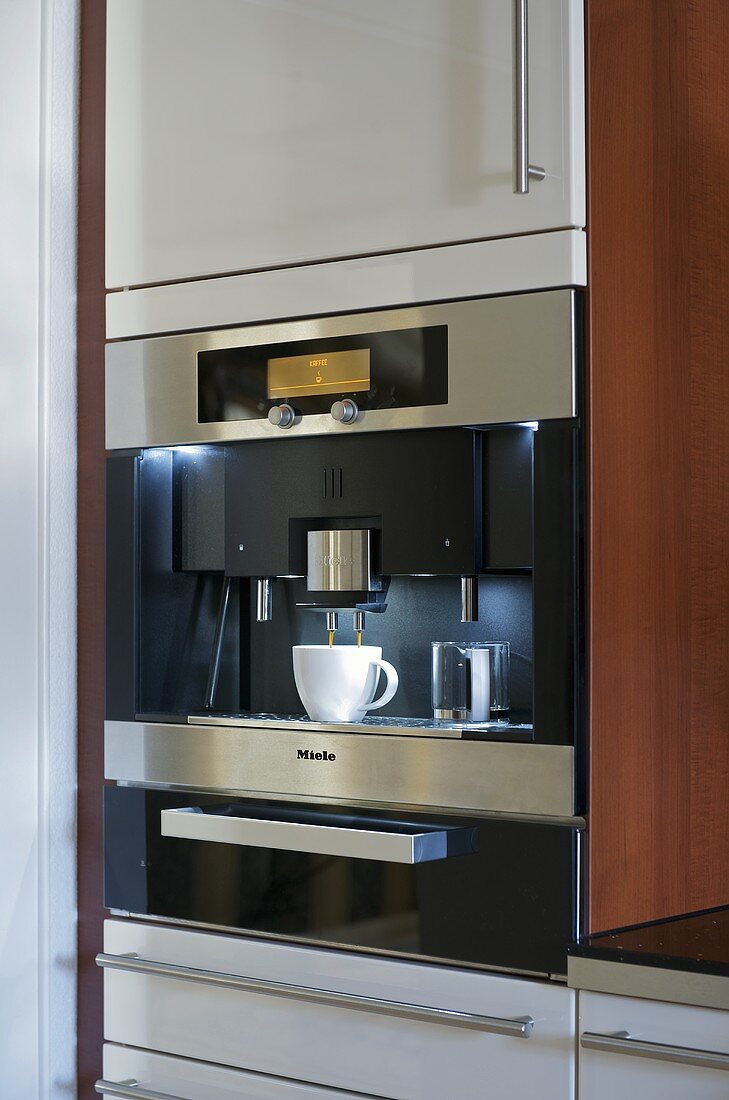 Moderne Kaffeemaschine im Küchenschrank
